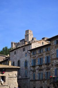 Low angle view of old building against clear blue sky