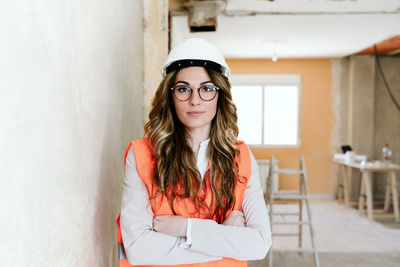 Professional confident architect woman in construction site with arms crossed. home renovation