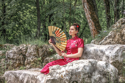 Portrait of woman sitting on rock