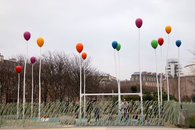 Low angle view of balloons against buildings in city