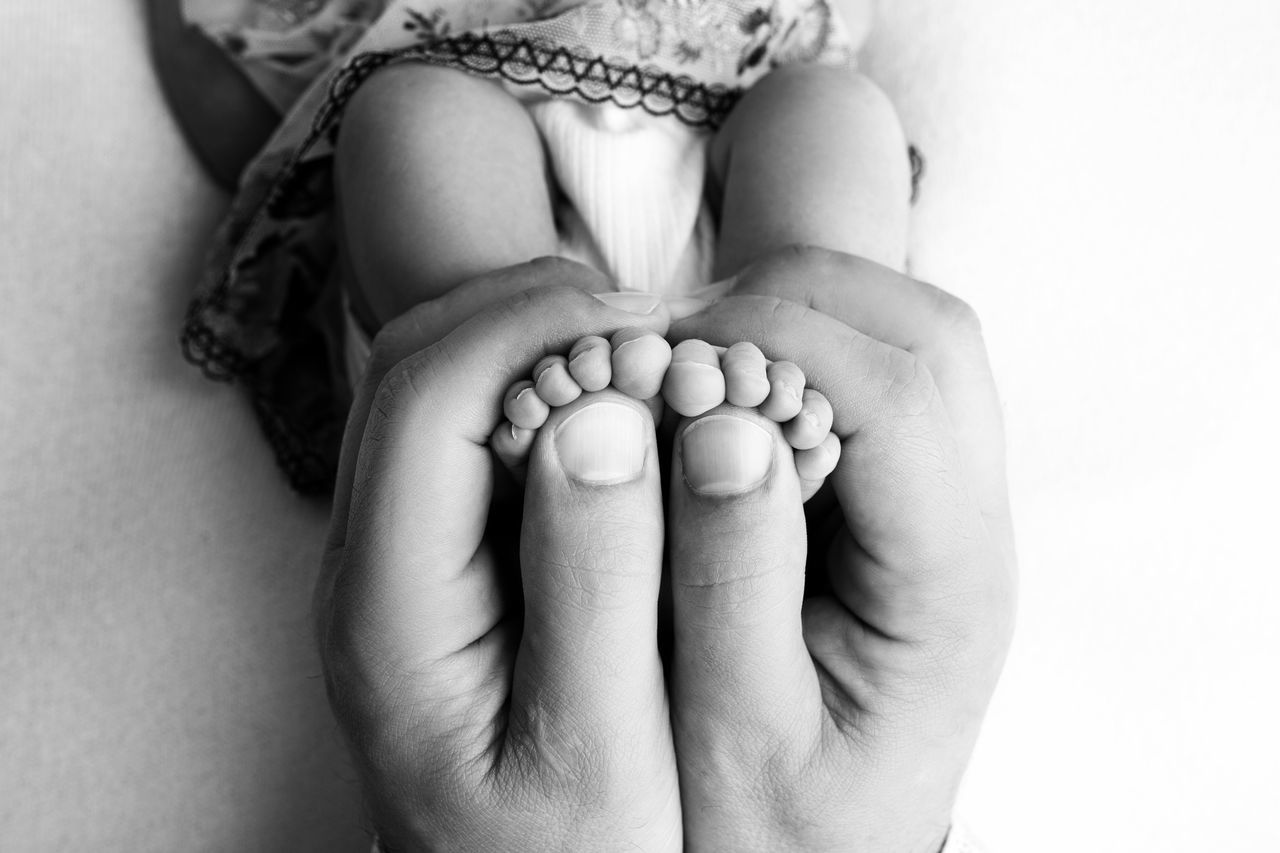 CLOSE-UP OF WOMAN HOLDING BABY FEET
