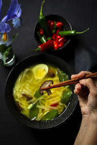 Cropped hand of person eating food at table