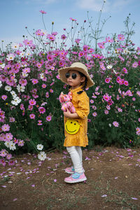 Woman standing by pink flowering plants