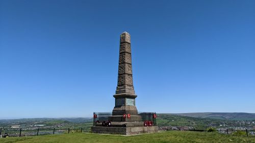 Built structure on landscape against blue sky