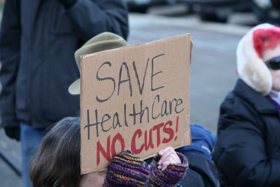 Woman holding cardboard with text