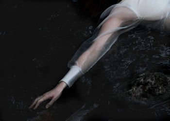 Low section of woman swimming in water