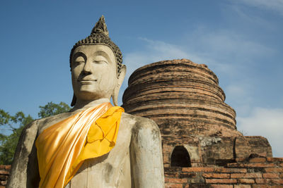 Low angle view of buddha statue against blue sky