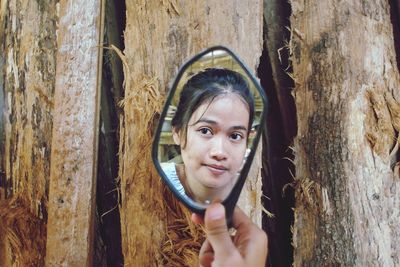 Portrait of smiling woman with tree trunk