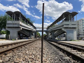 Railroad tracks by bridge against sky