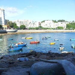Boats in river with buildings in background
