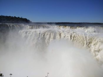 Scenic view of waterfall against sky