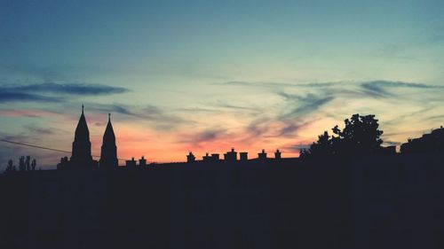 Silhouette of buildings against sky at sunset