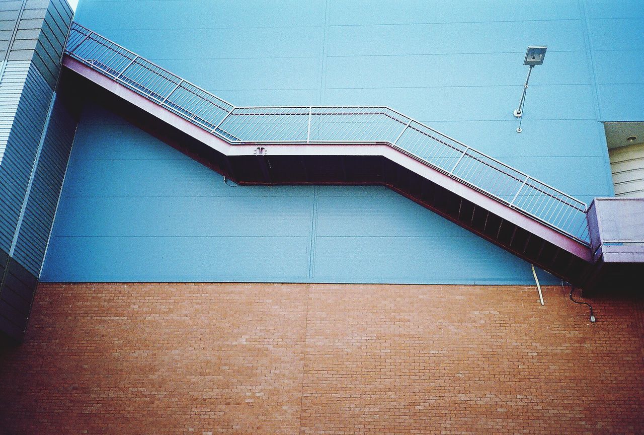 architecture, built structure, low angle view, building exterior, building, blue, wall - building feature, clear sky, window, brick wall, day, no people, directly below, outdoors, wall, modern, residential structure, sky, residential building, pattern