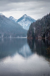 Scenic view of lake by snowcapped mountains against sky