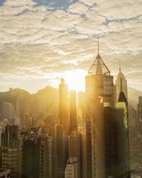 Buildings in city against cloudy sky