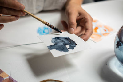 Close-up of man holding paper on table