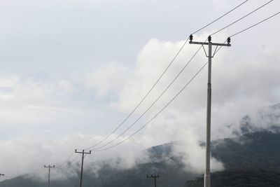 Low angle view of electricity pylon against sky