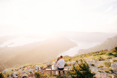 Rear view of man on mountain against sky