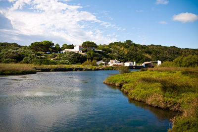 Scenic view of river against cloudy sky