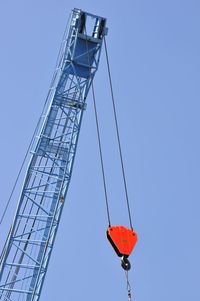 Low angle view of crane against clear sky