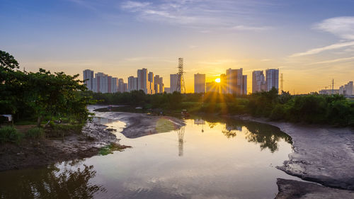 View of city at waterfront during sunset