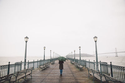 Rear view of woman walking on pier