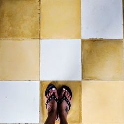 Low section of woman standing on tiled floor