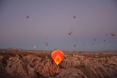 Hot air balloons on rock against sky