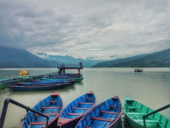 Boats moored in sea against sky