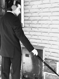 Side view of man working on wall