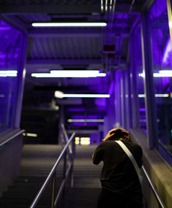 Rear view of woman standing at subway station