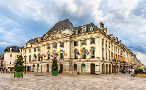 Facade of historic building against cloudy sky