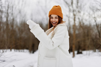 Portrait of young woman standing in snow