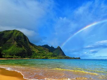 Scenic view of rainbow over sea against sky