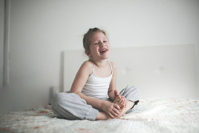 Funny laughing child girl, light background, real interior. concept childhood and emotions.