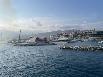 Wide panoramic view of the harbor of genoa. blue sky blue sea white clouds port buildings in harmony