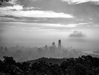 Buildings in city against cloudy sky