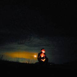 Silhouette person standing on field against sky at night