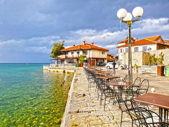 Houses on table by sea against sky