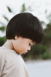 Side view of young woman looking away at beach