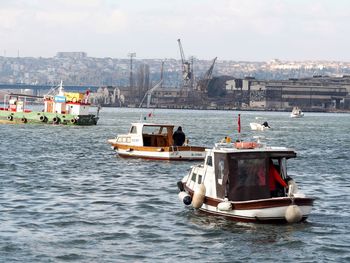 Boat sailing in sea against sky in city