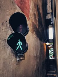 Low angle view of illuminated stoplight on wall