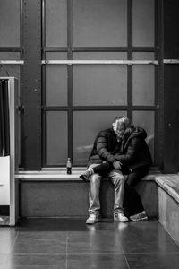 Full length of man sitting on floor in building