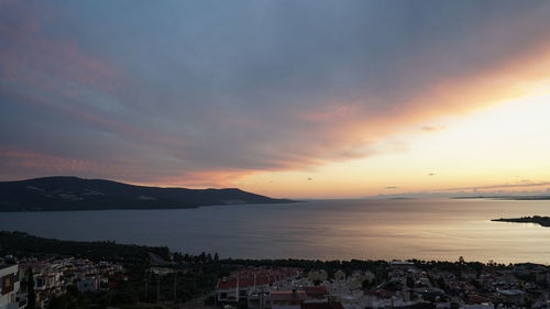 Scenic view of sea and buildings against sky during sunset