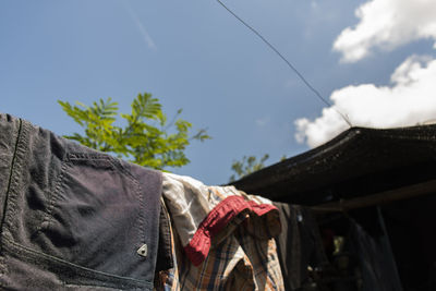 Low angle view of clothes hanging on roof against building