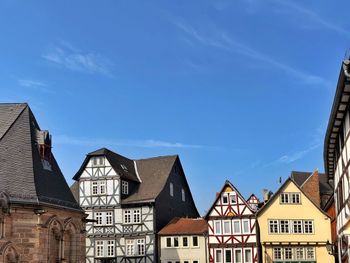 Low angle view of buildings in town against blue sky