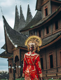 Woman standing outside temple against building