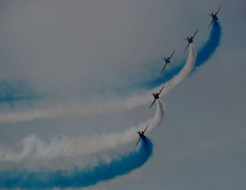 Low angle view of airshow against sky