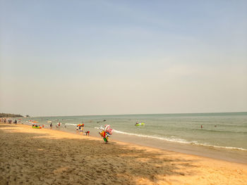 People at beach against sky