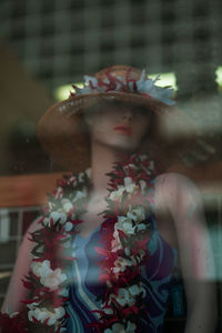 Midsection of woman with sculpture against window